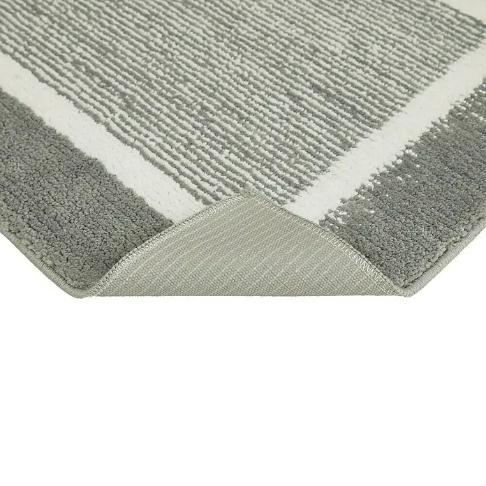 Badteppich Maui - 50 x 80 cm, Grau, 100% Polyester - Nahaufnahme eines grau-weißen Teppichs mit geometrischem Muster, der eine weiche Textur und ein modernes Design zeigt.