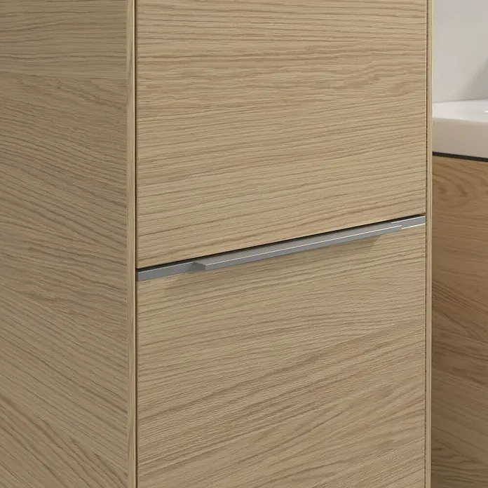 Villeroy & Boch Subway 3.0 Hochschrank - B x T x H: 40 x 36,2 x 171 cm, 2x Tür, Nordik oak, Farbe Griff: Aluminium glänzend, DIN Anschlag: Links - Nahaufnahme eines Badezimmerschranks mit hellem Holzfurnier und einem horizontalen, silberfarbenen Griff.