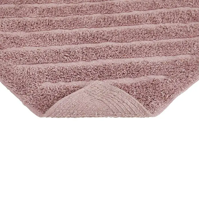 Badteppich Havanna - 50 x 80 cm, Rostrot, Stripe, 80% Baumwolle, 20% Polyester - Nahaufnahme eines flauschigen, rosa Badteppichs mit strukturierten Streifen und umgeschlagenem Rand, der die Verarbeitung zeigt.