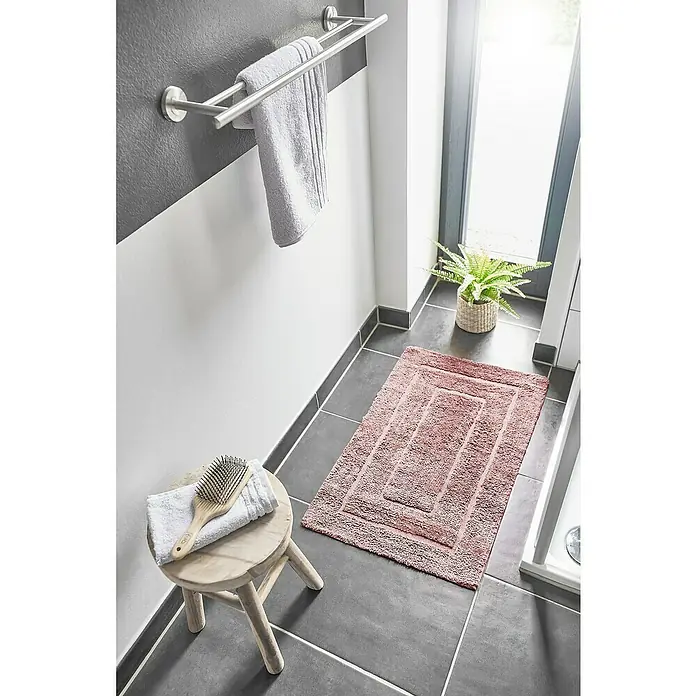Badteppich Havanna - 50 x 80 cm, Rostrot, Border, 80% Baumwolle, 20% Polyester - Ein rosa Badteppich mit einem rechteckigen Design und einem weißen Handtuch mit einer Bürste auf einem kleinen Hocker im Badezimmer.
