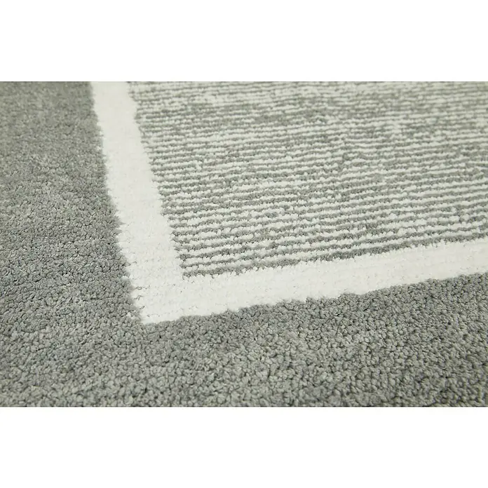 Badteppich Maui - 50 x 80 cm, Grau, 100% Polyester - Detailaufnahme eines Teppichs mit weißem Rand und grauem Muster. Weiche Textur und modernes Design.