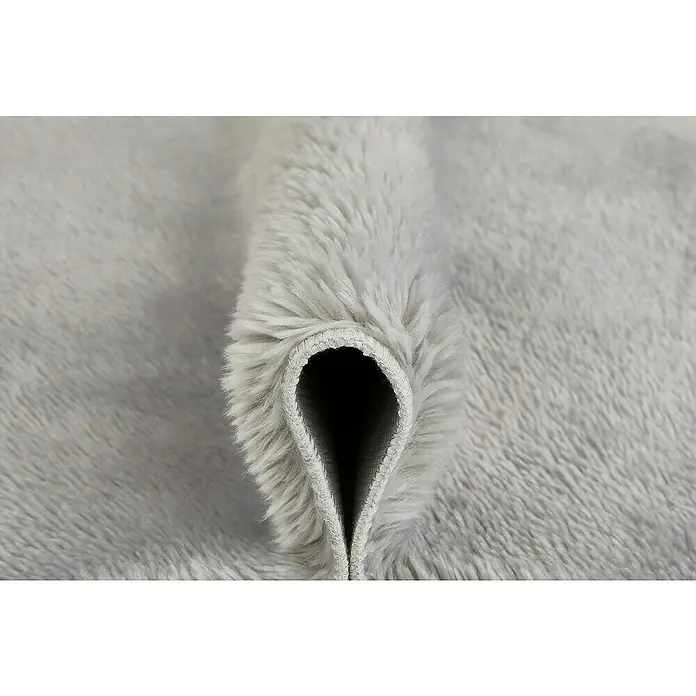 Badteppich Florida - 60 x 100 cm, Grau, 100% Polyester - Nahaufnahme eines hellgrauen, weichen Teppichs, der aufgerollt ist und seine flauschige Textur zeigt.