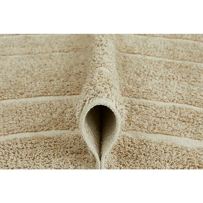 Badteppich Havanna - 50 x 80 cm, Beige, Border, 80% Baumwolle, 20% Polyester - Nahaufnahme eines beigen Teppichs mit horizontalen Linien und gefalteter Kante, der die Textur und das Material des Teppichs hervorhebt.