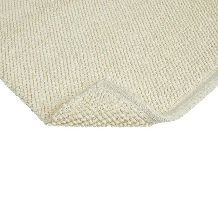 Badteppich Atlanta - 50 x 80 cm, Weiß, 100% Baumwolle - Detailaufnahme eines cremefarbenen Badteppichs mit hochfloriger Textur und umgeschlagenem Rand, der seine hochwertige Verarbeitung zeigt.