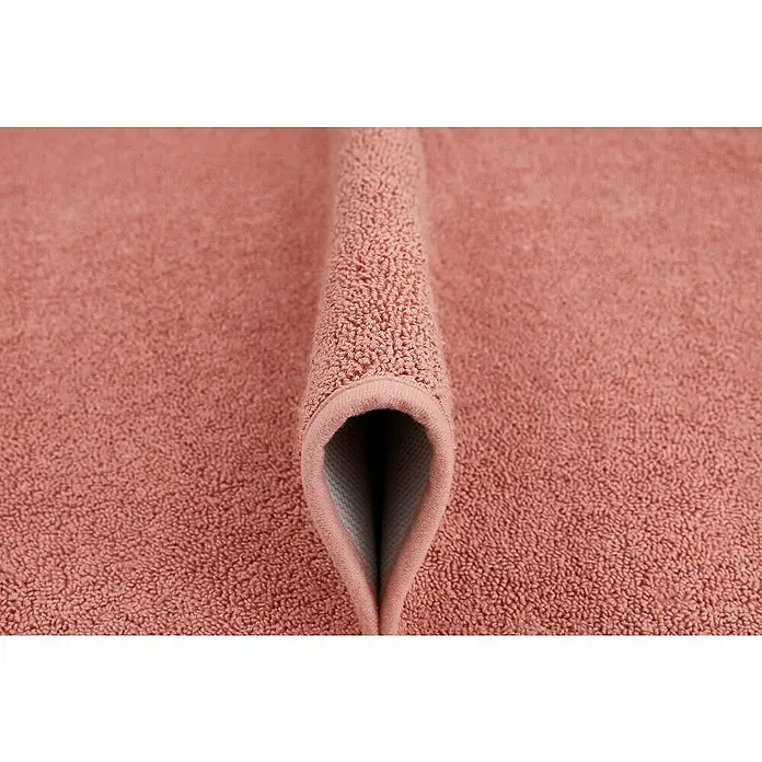 Badteppich Malibu - 60 x 100 cm, Rostrot, 100% Polyester - Nahaufnahme eines rosafarbenen Florwäscheteppichs mit sauberer, umgeschlagener Kante, der seine weiche Textur und hochwertige Verarbeitung hervorhebt.