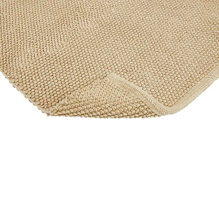 Badteppich Atlanta - 50 x 80 cm, Beige, 100% Baumwolle - Nahaufnahme eines beigefarbenen Badteppichs mit Noppenstruktur und umgeschlagener Ecke, der seine weiche Textur zeigt.