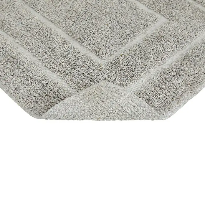 Badteppich Havanna - 50 x 80 cm, Taupe, Border, 80% Baumwolle, 20% Polyester - Detailaufnahme einer grauen Badematte mit geometrischem Muster und umgeschlagener Ecke, die die Textur zeigt.