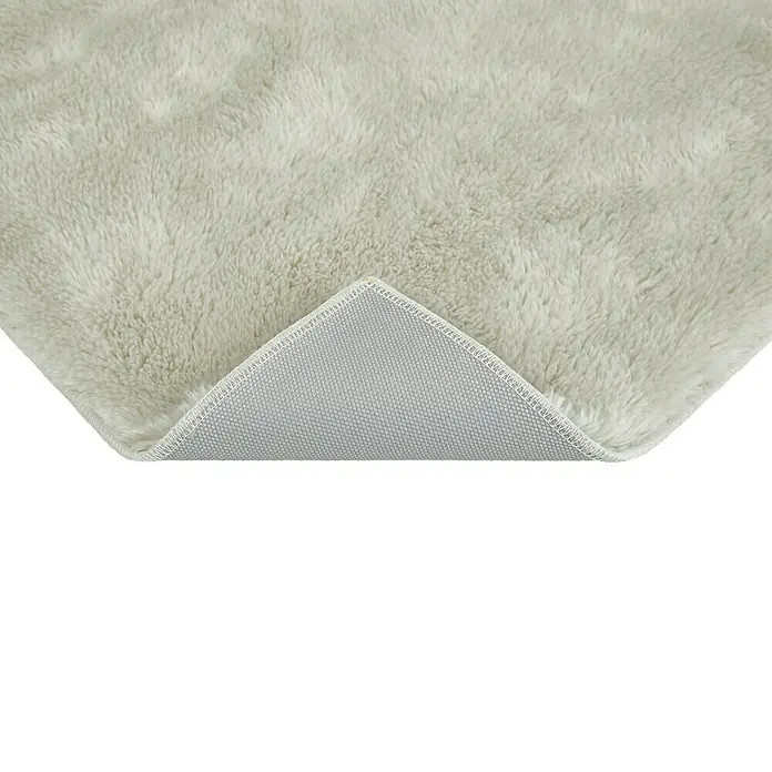 Badteppich Florida - 50 x 80 cm, Beige, 100% Polyester - Detailaufnahme der Rückseite eines flauschigen, cremefarbenen Teppichs, der seine hochwertige Verarbeitung und weiche Textur zeigt.