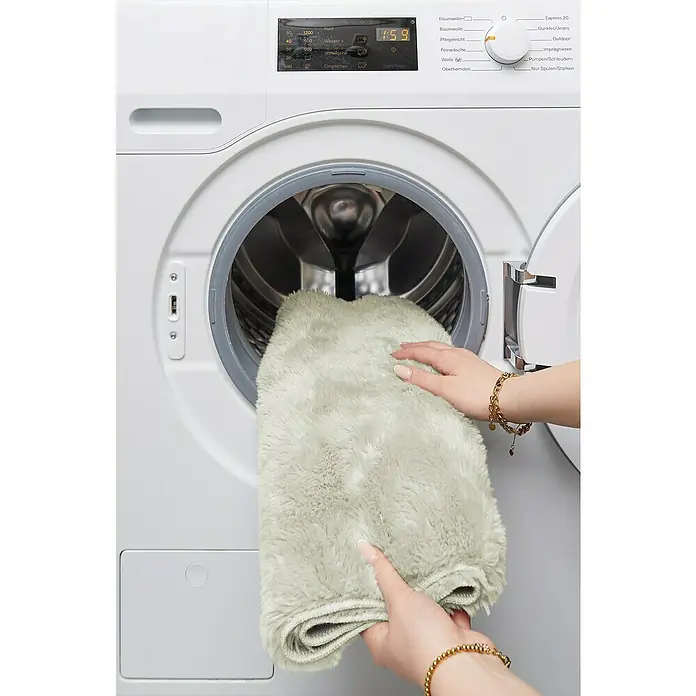 Badteppich Florida - 50 x 80 cm, Beige, 100% Polyester - Flauschiger Teppich wird in eine weisse Miele Waschmaschine gelegt.