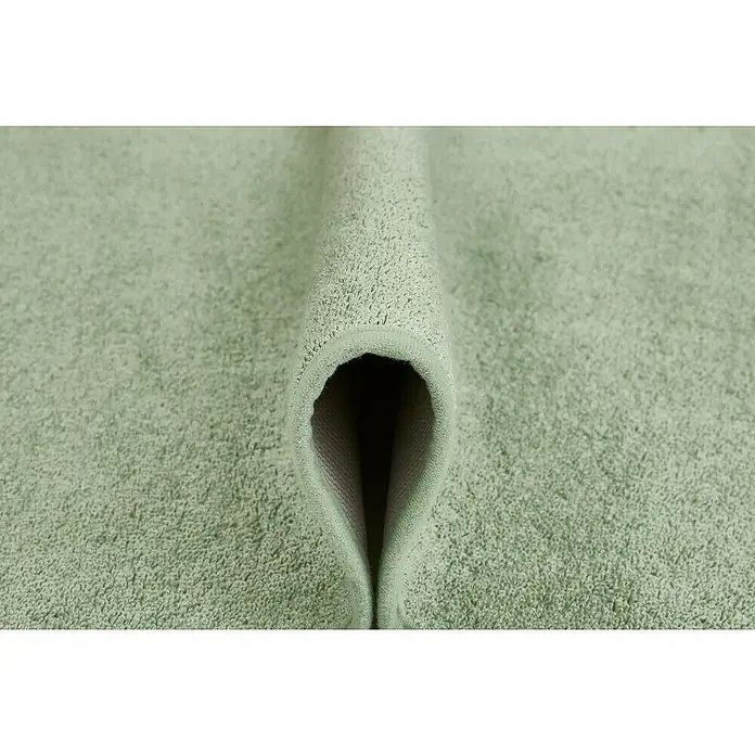 Badteppich Malibu - 60 x 100 cm, Salbei, 100% Polyester - Nahaufnahme eines gefalteten, hellgrünen Badteppichs, der eine weiche Textur und hochwertige Verarbeitung zeigt. Ideal für Badezimmer.