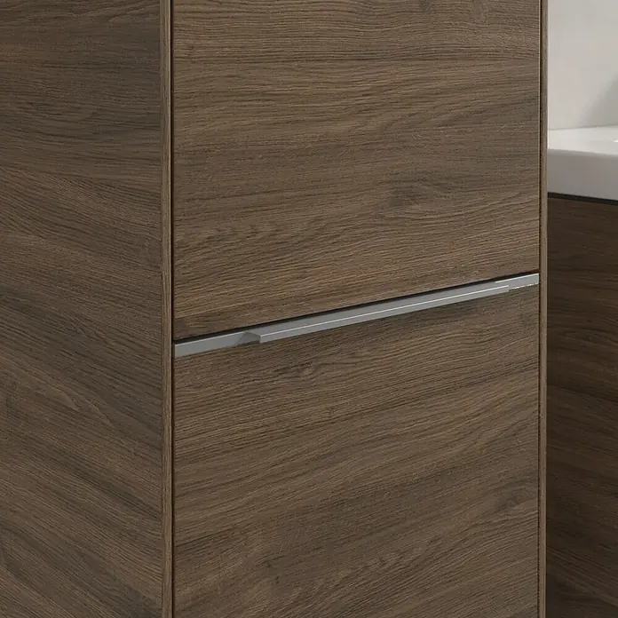 Villeroy & Boch Subway 3.0 Hochschrank - B x T x H: 40 x 36,2 x 171 cm, 2x Tür, Arizona Oak, Farbe Griff: Aluminium glänzend, DIN Anschlag: Links - Detailaufnahme eines Badezimmerschranks in Holzoptik mit einem schlanken, silbernen Griff, der modernes Design und Funktionalität vereint.
