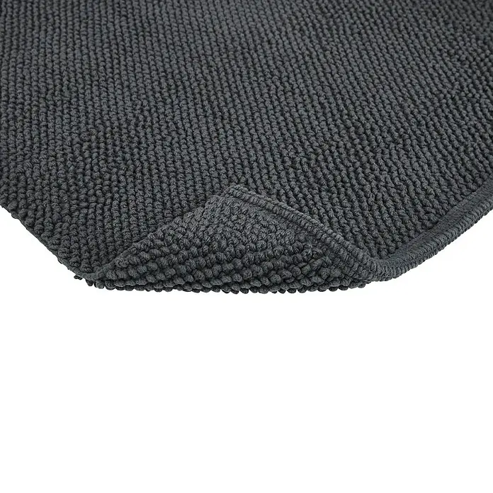 Badteppich Atlanta - 50 x 80 cm, Anthrazit, 100% Baumwolle - Nahaufnahme einer grauen Badematte mit gewebter Textur und umgeschlagener Ecke, die die Qualität hervorhebt.