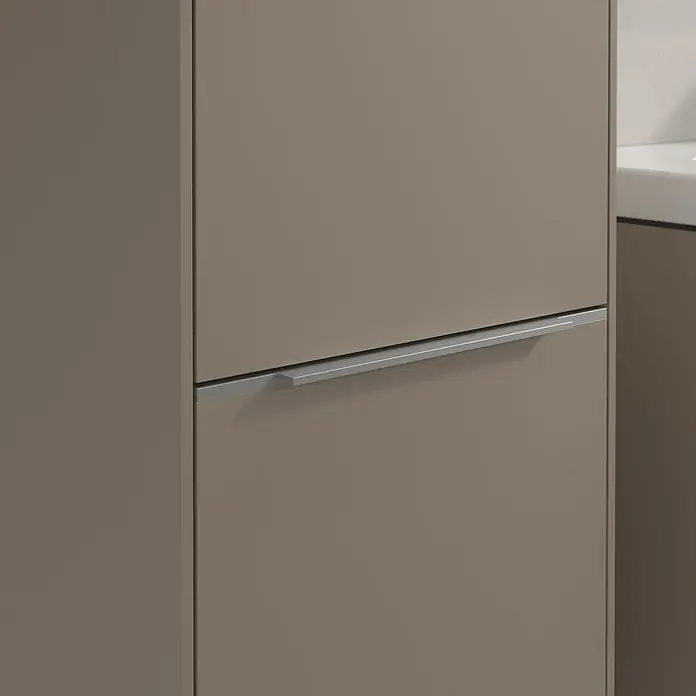 Villeroy & Boch Subway 3.0 Hochschrank - B x T x H: 40 x 36,2 x 171 cm, 2x Tür, Taupe, Farbe Griff: Aluminium glänzend, DIN Anschlag: Links - Nahaufnahme eines braunen Schrankes mit einem horizontalen, silberfarbenen Griff. Das Möbelstück wirkt modern und minimalistisch.