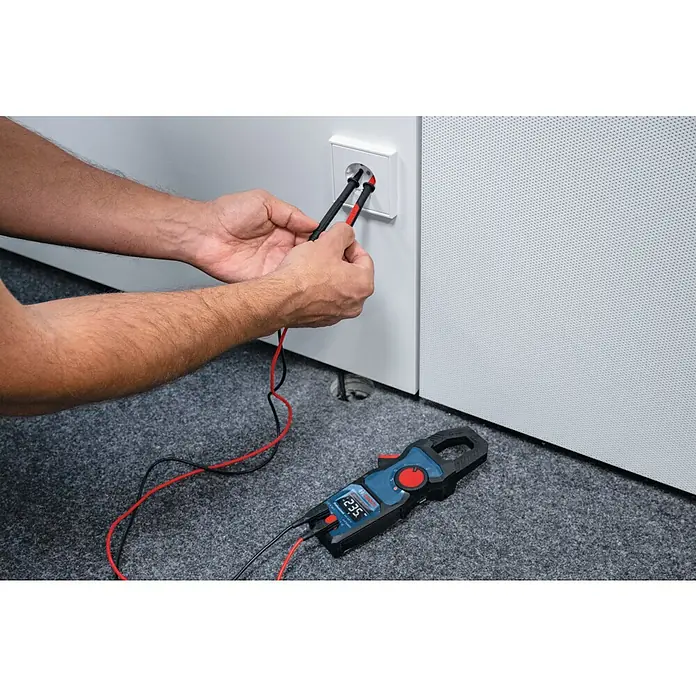 Bosch Professional Stromzange GMC 600-15 - 600 V, Blau, Schwarz - Elektriker prüft mit einem Bosch Multimeter die Spannung einer Steckdose. Das Messgerät zeigt 235 V an.