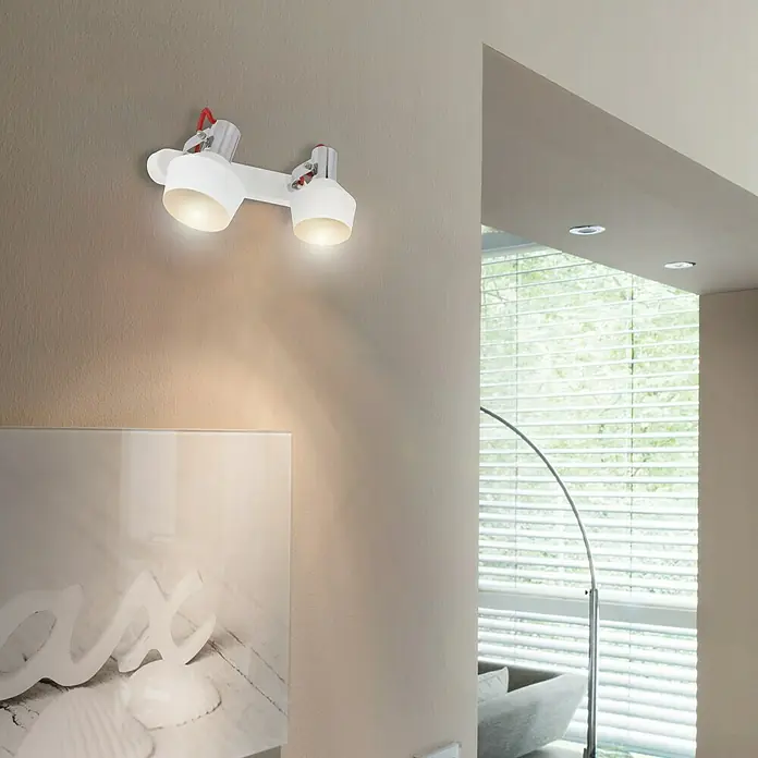 Tween Light Deckenstrahler Grado - 8 W, L x B x H: 26 x 9,5 x 19,2 cm, Weiß, E14 - Wandleuchte mit zwei Strahlern, die warmes Licht ausstrahlen, montiert an einer beigen Wand. Moderne Innenraumbeleuchtung für Ihr Zuhause.
