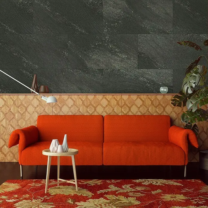 Grosfillex Wall+ Wandpaneel - Black Stone, 600 x 300 x 5 mm - Nahaufnahme eines orangefarbenen Sofas mit Beistelltisch und Dekor, das ein gemütliches und stilvolles Wohnzimmerambiente zeigt.
