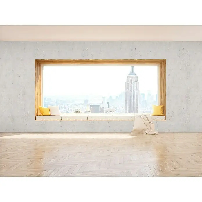 Grosfillex Wandpaneel Element 3D - Beton New York Weiss, 2.600 x 375 x 8 mm - Helles Interieur mit großem Fenster, das einen Blick auf die Skyline von New York City bietet. Ein Fensterbrett mit Kissen lädt zum Verweilen ein.