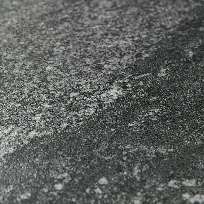 Grosfillex Wall+ Wandpaneel - Black Stone, 600 x 300 x 5 mm - Nahaufnahme einer strukturierten, grauen Oberfläche, die an Stein oder Beton erinnert, mit subtilen weißen Akzenten.