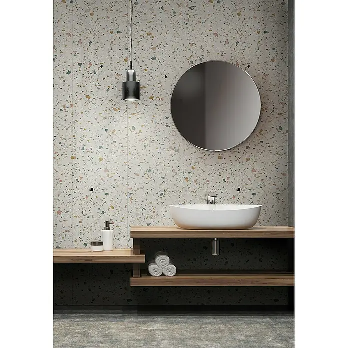 Grosfillex Wandpaneel Element 3D - Terrazzo White, 2.600 x 375 x 8 mm - Modernes Badezimmer mit rundem Spiegel und Aufsatzwaschbecken auf Holzablage vor einer Terrazzo-Wand für eine stilvolle Atmosphäre.