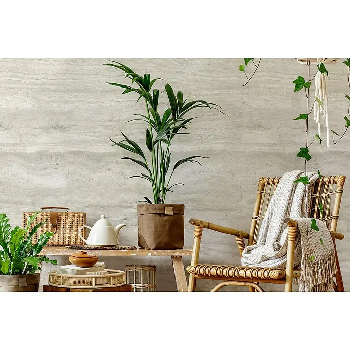 Grosfillex Wandpaneel Element 3D - Romano Bianco, 2.600 x 375 x 8 mm - Zimmerpflanze in braunem Topf auf einem Holzregal neben einem Rattan-Sessel mit einer Decke, die eine gemütliche und entspannende Atmosphäre schafft.