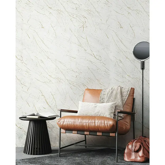 Grosfillex Wandpaneel Element 3D - Marble Calacatta, 2.600 x 375 x 8 mm - Nahaufnahme eines Sessels mit braunem Lederbezug, einem Kissen und einer Decke, der vor einer Marmorwand steht.