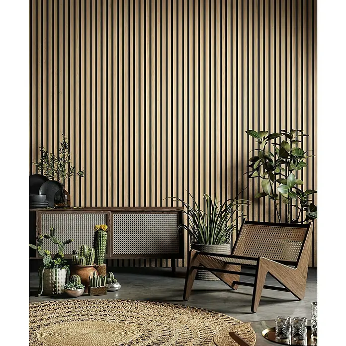 Grosfillex Wandpaneel Element 3D - Linio Ash, 2.600 x 375 x 8 mm - Elegantes Interieur mit einem Rattan-Sessel, einem Sideboard und verschiedenen Pflanzen vor einer Wand mit Holzlamellen.