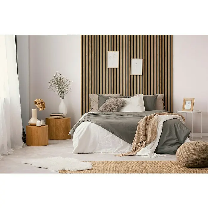 Grosfillex Wandpaneel Element 3D - Linio Light, 2.600 x 375 x 8 mm - Schlafzimmer mit einem Bett, das mit einer grauen Tagesdecke, Kissen und einer Holzwand verziert ist.
