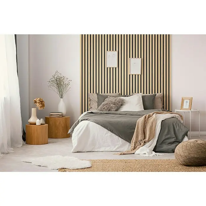 Grosfillex Wandpaneel Element 3D - Linio Ash, 2.600 x 375 x 8 mm - Dieses Schlafzimmer zeigt ein Bett mit grauem Tagesdecke, Holzpaneele an der Wand und eine gemütliche Atmosphäre.