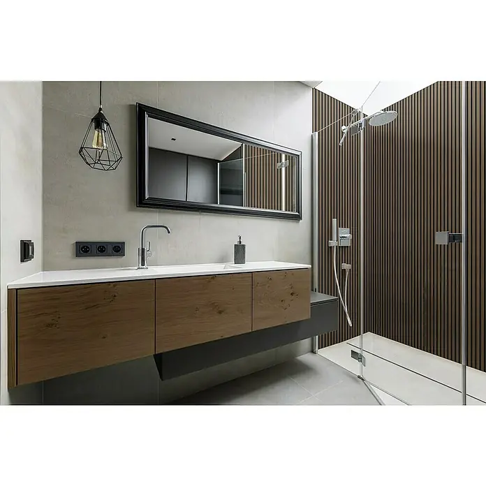 Grosfillex Wandpaneel Element 3D - Linio Walnut, 2.600 x 375 x 8 mm - Elegantes Badezimmer mit Waschtischunterschrank in Holzoptik, großem Spiegel und moderner Dusche mit Holzpaneelen. Die stilvolle Beleuchtung rundet das Design ab.