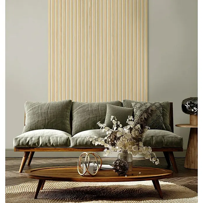 Grosfillex Wandpaneel Element 3D - Linio Bright Ash, 2.600 x 375 x 8 mm - Stilvolles Wohnzimmer-Interieur mit einem modernen Sofa mit grünen Kissen und einem ovalen Holztisch mit dekorativen Elementen.