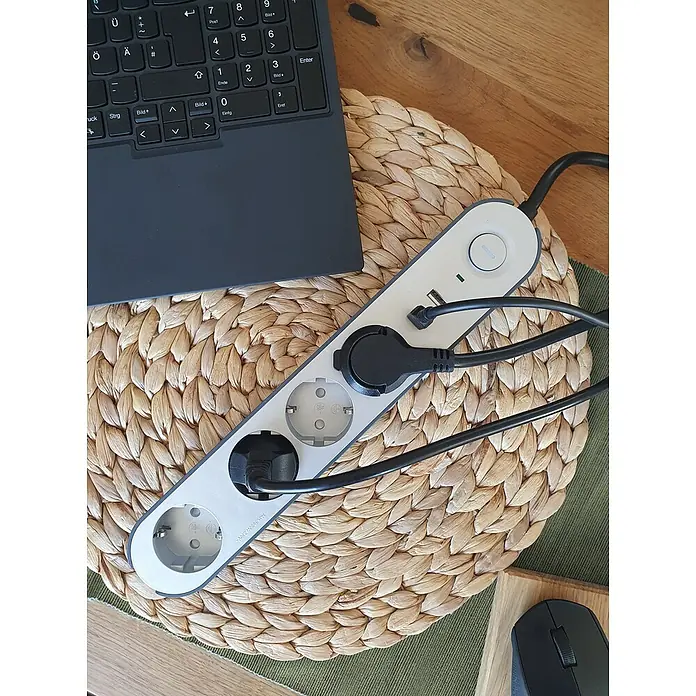 UniTEC Steckdosenleiste Greenline USB - Anzahl Steckdosen Schuko: 4 Stk., Silber, Anthrazit, Kabellänge: 1,8 m, Mit Schalter - Eine Mehrfachsteckdose mit mehreren eingesteckten Kabeln und einem Laptop auf einem Tisch.
