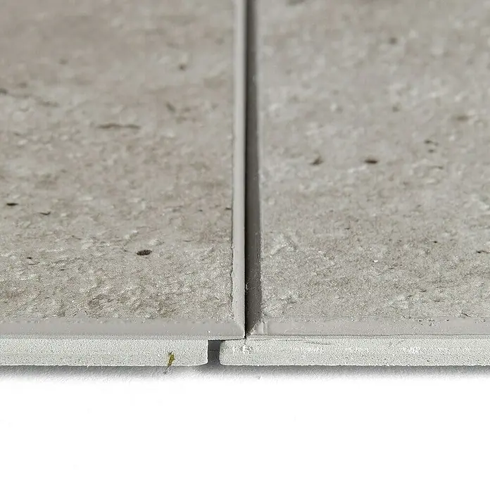 Grosfillex Wall+ Wandpaneel - Grey Concrete, 1.200 x 600 x 5 mm - Nahaufnahme von zwei grauen Fliesen mit einer schmalen Fuge dazwischen, die die Textur und Farbe der Fliesen hervorhebt.
