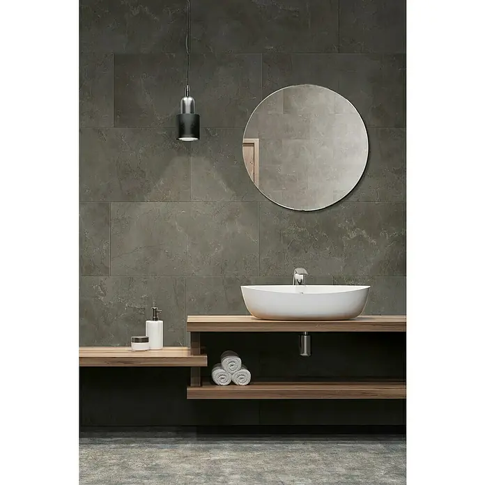 Grosfillex Wall+ Wandpaneel - Grey Marble, 600 x 300 x 5 mm - Ein modernes Badezimmer mit einem runden Spiegel, einer eleganten Waschtischarmatur und einer stilvollen hängenden Lampe, die den Raum aufwertet.