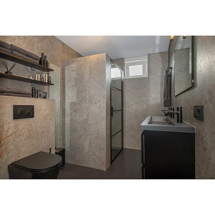 Grosfillex Wall+ Wandpaneel - Grey Concrete, 2.600 x 600 x 5 mm - Modernes Badezimmer mit schwarzer Toilette, Waschtisch und Duschkabine vor grauen Wänden, stilvoll und minimalistisch eingerichtet.