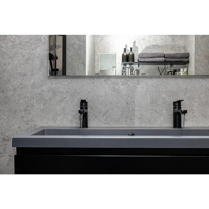Grosfillex Wall+ Wandpaneel - Grey Concrete, 2.600 x 600 x 5 mm - Elegantes Badezimmerwaschbecken mit zwei schwarzen Armaturen, die das moderne Design hervorheben und für einen stilvollen Look sorgen.