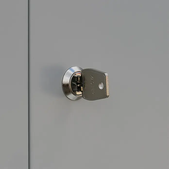 Lüllmann Schließfachschrank - H x B x T: 180 x 31,5 x 50 cm, Lichtgrau/Enzianblau, Fertig montiert, Anzahl Fächer: 3 Stk. - Nahaufnahme eines silbernen Schlüssels, der in einem Schloss steckt, das in eine graue Oberfläche eingelassen ist.