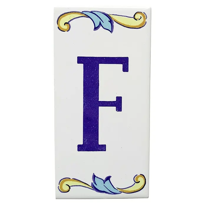 Pavimento cerámico Letra F - 7,5 x 15 cm, Blanco/Azul/Amarillo, Brillante - Azulejo de cerámica con la letra F y elementos florales decorativos en amarillo y azul.