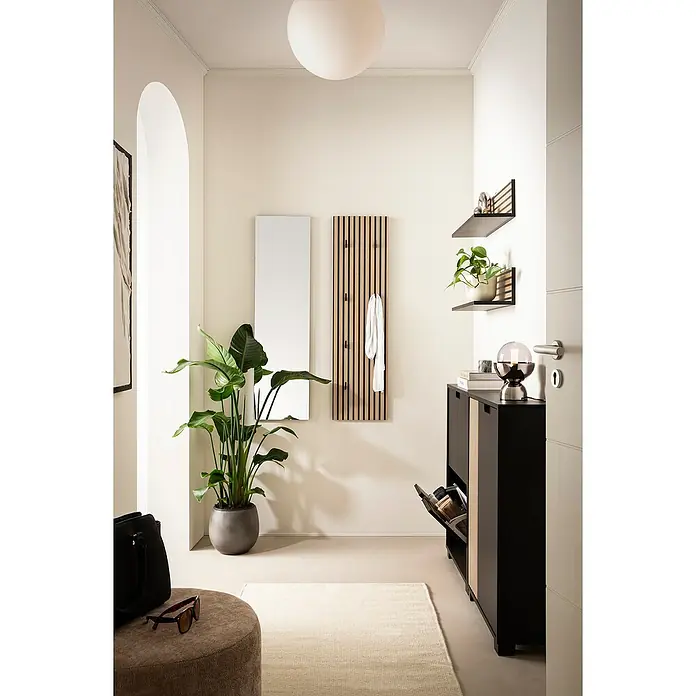 Schildmeyer Ryker Schrank - L x B x H: 19,5 x 59,8 x 85,2 cm, Schwarz - Heller Flur mit einem schwarzen Schuhschrank mit Holzdetails, Regalen, Spiegel, Garderobe und einer großen Pflanze im Topf.