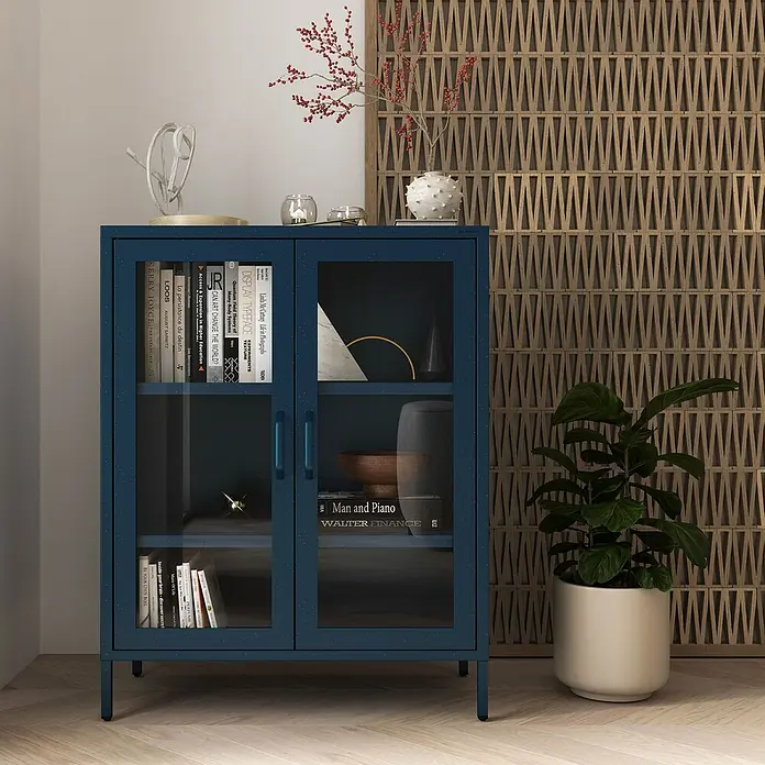 Jan Nowak Vitrine Gina - B x T x H: 80 x 40 x 101,5 cm, Dunkelblau - Nahaufnahme eines blauen Glasschranks mit Büchern und Dekor, der ein stilvolles und funktionales Möbelstück zeigt.