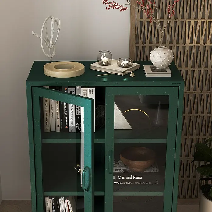 Jan Nowak Vitrine Gina - B x T x H: 80 x 40 x 101,5 cm, Flaschengrün - Nahaufnahme eines grünen Glasschranks mit Büchern, Dekorationen und einer skulpturalen Note, die modernes Design und Funktionalität vereint.