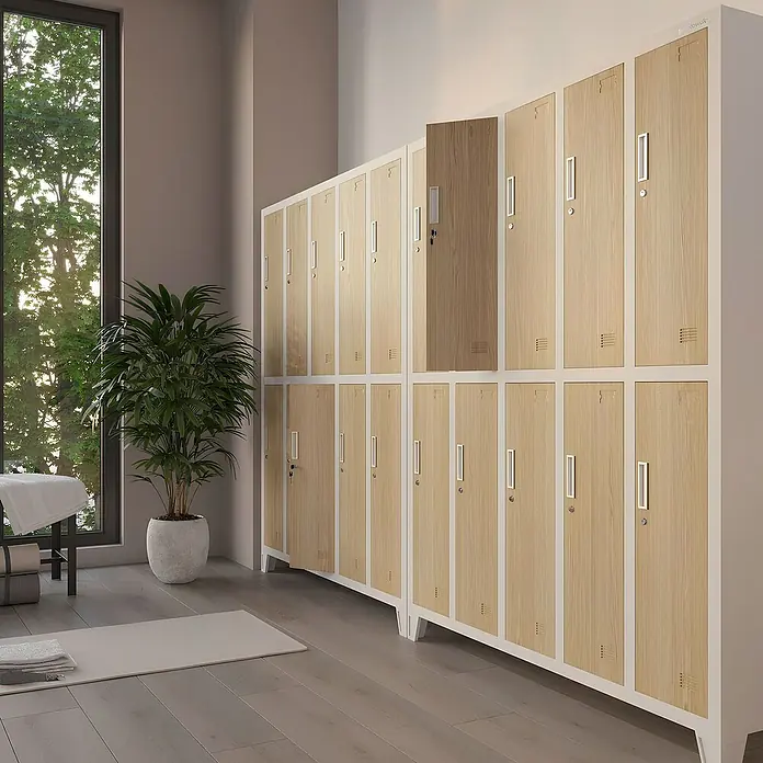 Jan Nowak Spind Bartek - B x T x H: 136 x 45 x 172 cm, Weiß / Sonoma Eiche - Diese Aufnahme zeigt helle Holzschließfächer in einem Fitnessstudio oder Spa-Bereich mit einem großen Fenster und einer Zimmerpflanze.