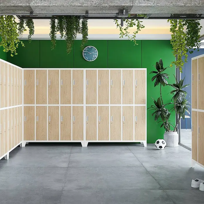 Jan Nowak Spind Bartek - B x T x H: 136 x 45 x 172 cm, Weiß / Sonoma Eiche - Holzfarbene Schließfächer mit weißen Rahmen stehen in einem Raum mit Betonboden und grüner Wand, dekoriert mit Pflanzen.