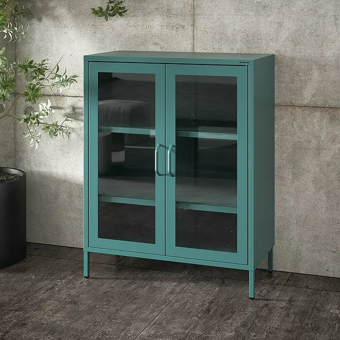 Jan Nowak Vitrine Gina - B x T x H: 80 x 40 x 101,5 cm, Meeresgrün - Ein grüner Schrank mit Glastüren steht vor einer grauen Wand. Der Schrank hat mehrere Regale und schlanke Beine.