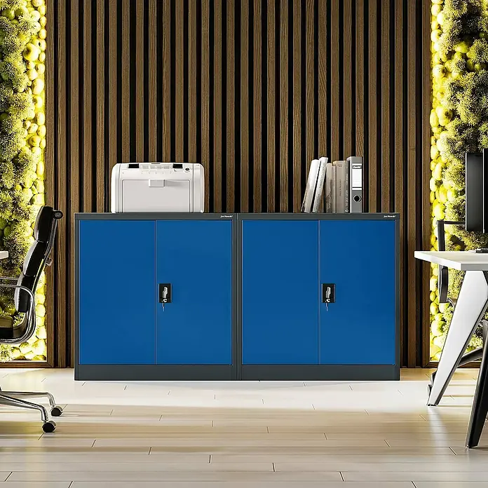 Jan Nowak Aktenschrank Beata - B x T x H: 90 x 40 x 92,5 cm, Anthrazit / Blau - Büro mit blauen Aktenschränken, Drucker, Büchern und Büromaterialien vor einer strukturierten Wand.