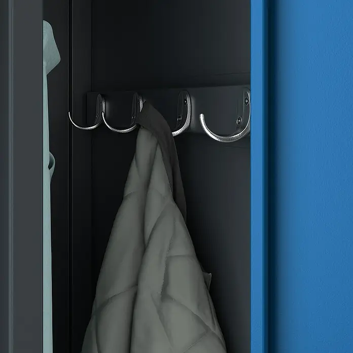 Jan Nowak Spind Kacper - H x B x T: 180 x 80 x 50 cm, Anthrazit/Blau, Anzahl Türen: 2 Stk., Anzahl Fächer: 4 Stk. - Garderobe mit Jacke an Haken. Die graue Jacke hängt an einem der silbernen Haken in der schwarzen Garderobe. Rechts ist eine blaue Wand zu sehen.