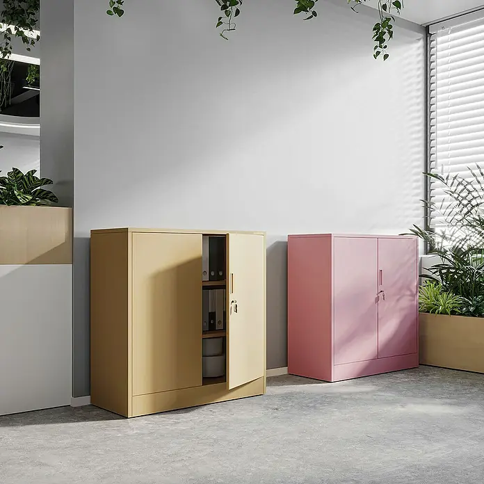 Jan Nowak Aktenschrank Beata - B x T x H: 90 x 40 x 92,5 cm, Rosa - Modernes Büro mit beigem Schrank, dessen Tür geöffnet ist, und einem rosafarbenen Schrank vor einem Fenster mit Jalousien.