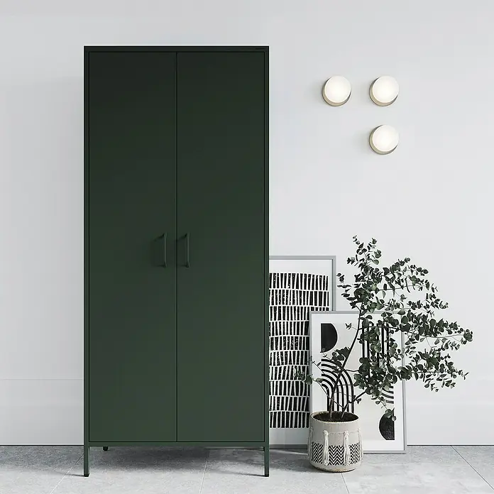 Jan Nowak Kleiderschrank Flavio - H x B x T: 185 x 80 x 45 cm, Flaschengrün - Ein grüner Garderobenschrank mit zwei Türen steht in einem Raum mit Kunstwerken und einer Pflanze. Der Schrank bietet viel Stauraum und ist ein stilvolles Möbelstück.