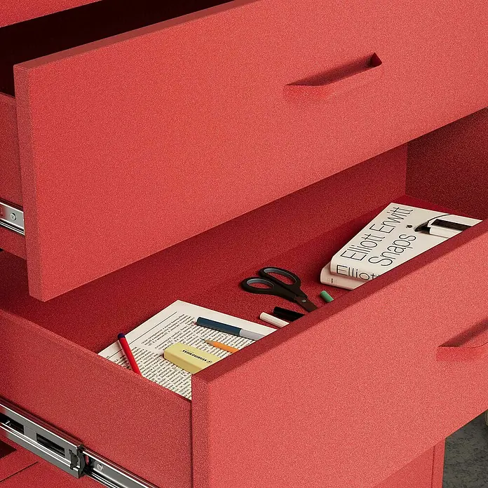Jan Nowak Kommode Carla - L x B x H: 40 x 80 x 101,5 cm, Rot, Anzahl Schubladen: 4 Stk. - Nahaufnahme eines roten Schreibtischs mit offenen Schubladen, gefüllt mit Bürobedarf und einem Buch, das eine organisierte und kreative Arbeitsumgebung zeigt.