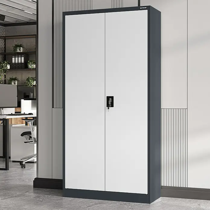 Jan Nowak Aktenschrank Jan - B x T x H: 90 x 40 x 185 cm, Anthrazit/Weiß - Ein grauer Büroschrank mit weißen Türen und einem Schloss. Der Schrank steht in einem modernen Büro mit Regalen und Pflanzen.