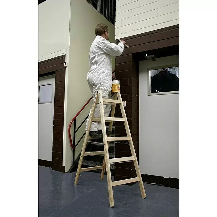 Krause Stabilo Escalera doble - Número de peldaños: 10 ud., Altura de trabajo: 2,75 m, Carga soportada: 150 kg, Madera - Escalera de mano de madera natural que sostiene a un pintor trabajando en una pared.